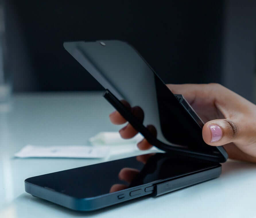Person putting screen protector on iPhone
